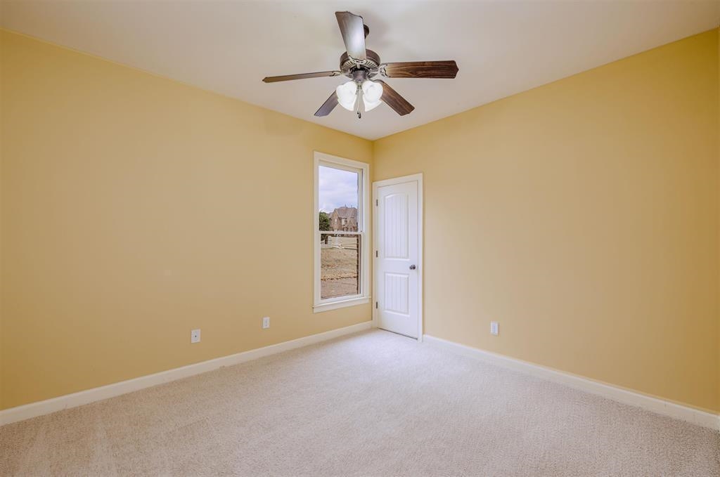 5380 Scarlet Ridge Drive Arlington, TN 38002 - Photo 20 of 35 Carpeted room featuring a ceiling fan with integrated lighting, a paneled door, and a white-framed window