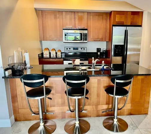 a kitchen with stainless steel appliances kitchen island granite countertop dining table and chairs