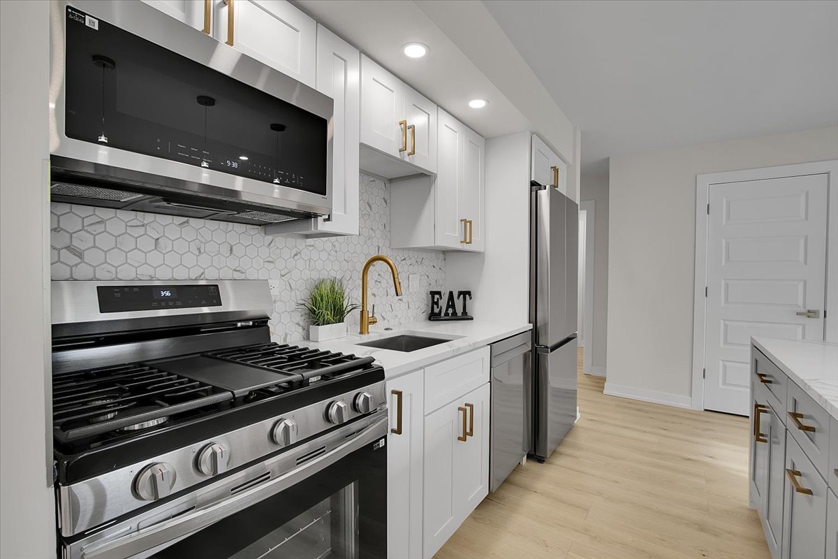 1109 71st Street Darien, IL 60561 - Photo 13 of 41 a kitchen with stainless steel appliances a sink a stove and a microwave