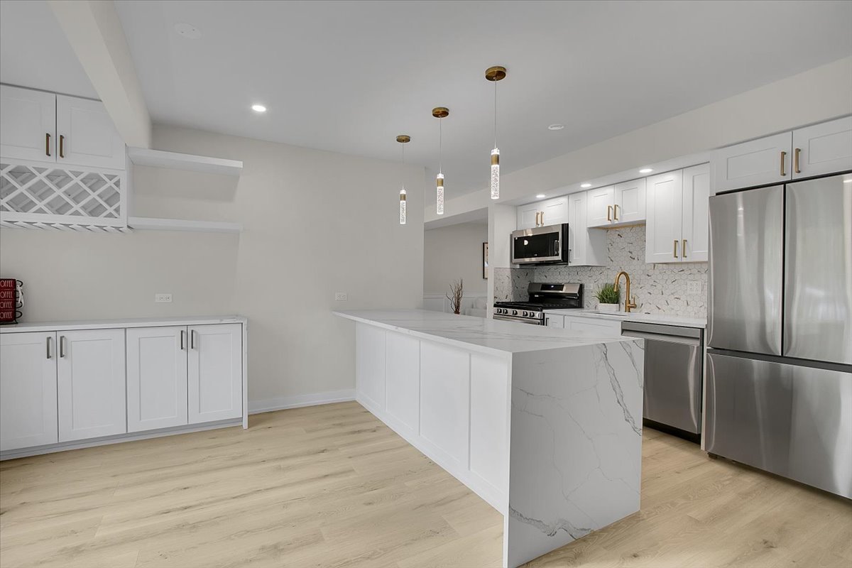 1109 71st Street Darien, IL 60561 - Photo 15 of 41 a large white kitchen with cabinets and stainless steel appliances