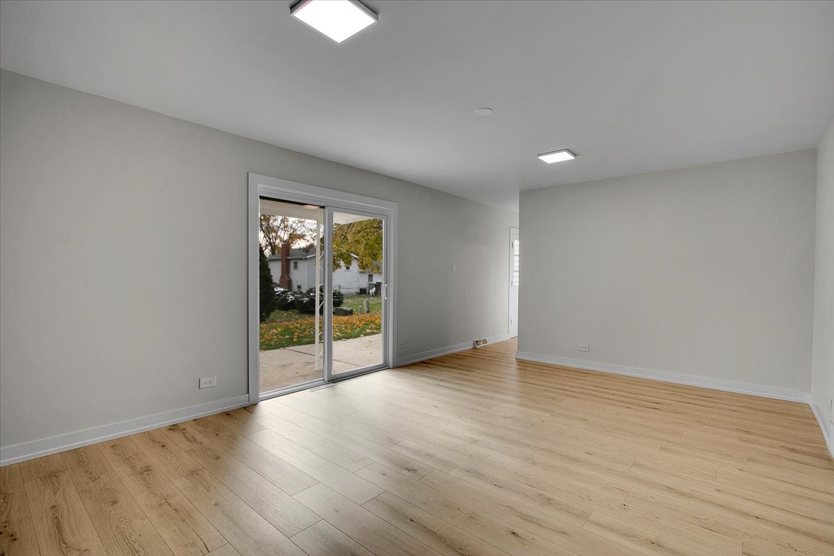 1109 71st Street Darien, IL 60561 - Photo 22 of 41 a view of an empty room with wooden floor and a window