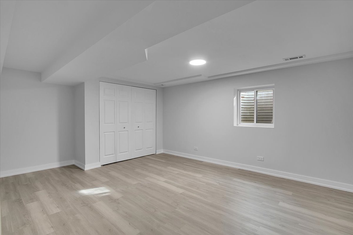 1109 71st Street Darien, IL 60561 - Photo 36 of 41 a view of an empty room with wooden floor and a window
