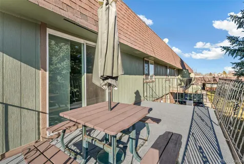 a view of a patio with table and chairs with wooden floor and fence