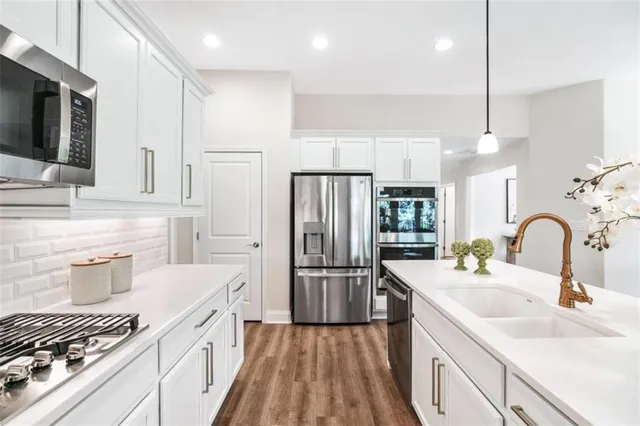 a kitchen with a sink stainless steel appliances and cabinets