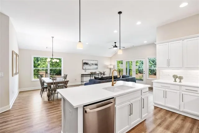 a kitchen with a stove a sink a window and chairs