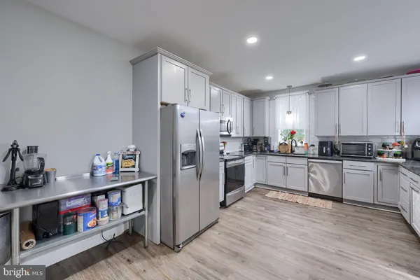 a kitchen with refrigerator a microwave and wooden floor