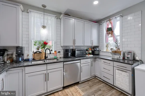 a kitchen with a sink dishwasher cabinets and white appliances
