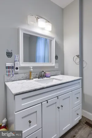 a bathroom with a granite countertop sink and a mirror