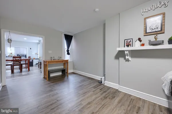 a view of a room that has wooden floor and furniture
