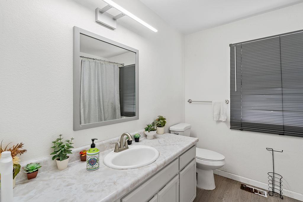672 Irwin Lane Santa Rosa, CA 95401 - Photo 27 of 35 a bathroom with a granite countertop sink toilet and mirror