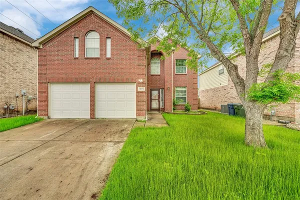 a front view of a house with a yard and trees