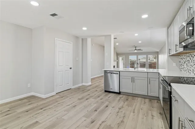 a large kitchen with a lot of counter space and wooden floor