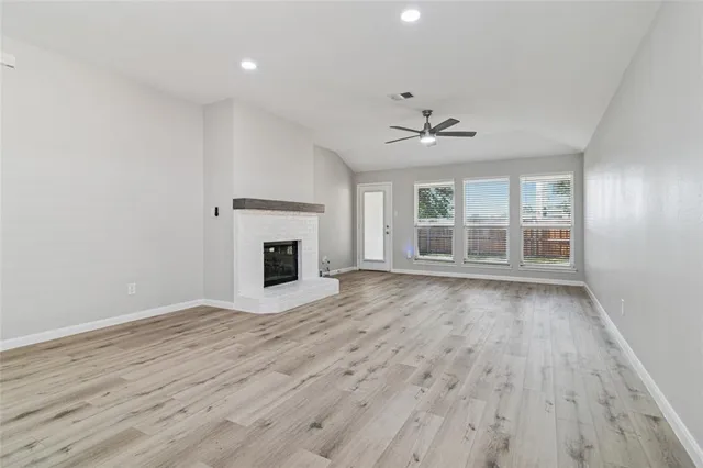 a view of an empty room with a fireplace and a window