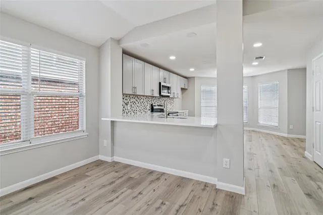 a view of kitchen with wooden floor and electronic appliances