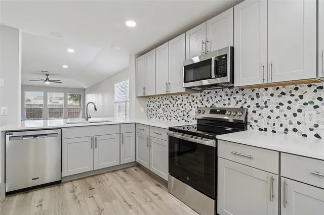 a kitchen with granite countertop cabinets stainless steel appliances and wooden floor
