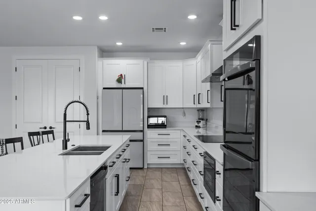 a kitchen with kitchen island a sink stove and refrigerator