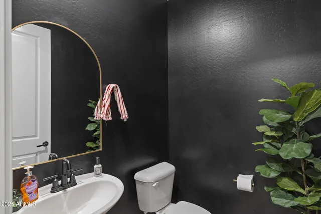 a bathroom with a toilet sink and mirror