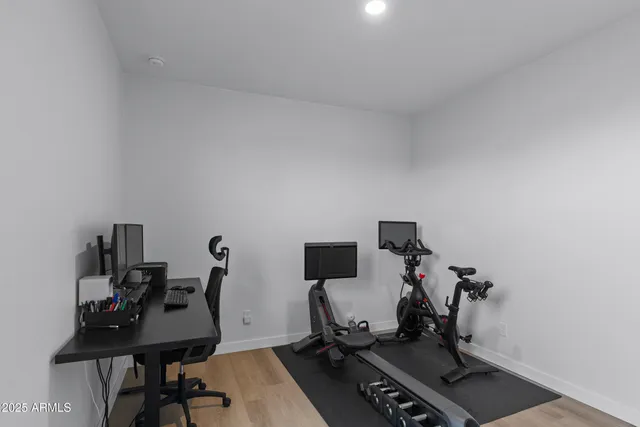 a view of a workspace with furniture and a gym machine