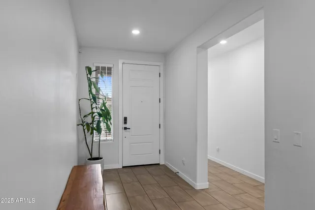 an empty room with windows and potted plants
