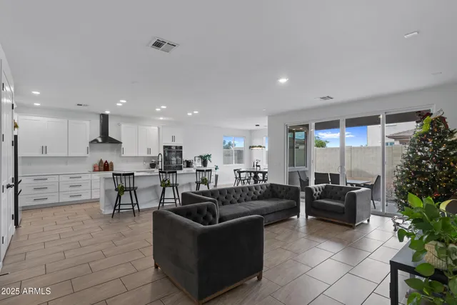 a living room with furniture wooden floor and a large window