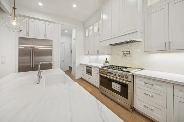 a kitchen with kitchen island granite countertop a sink and refrigerator