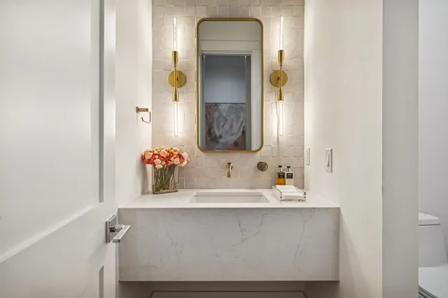 a large kitchen with stainless steel appliances kitchen island a large counter top a stove a chimney a sink and cabinets