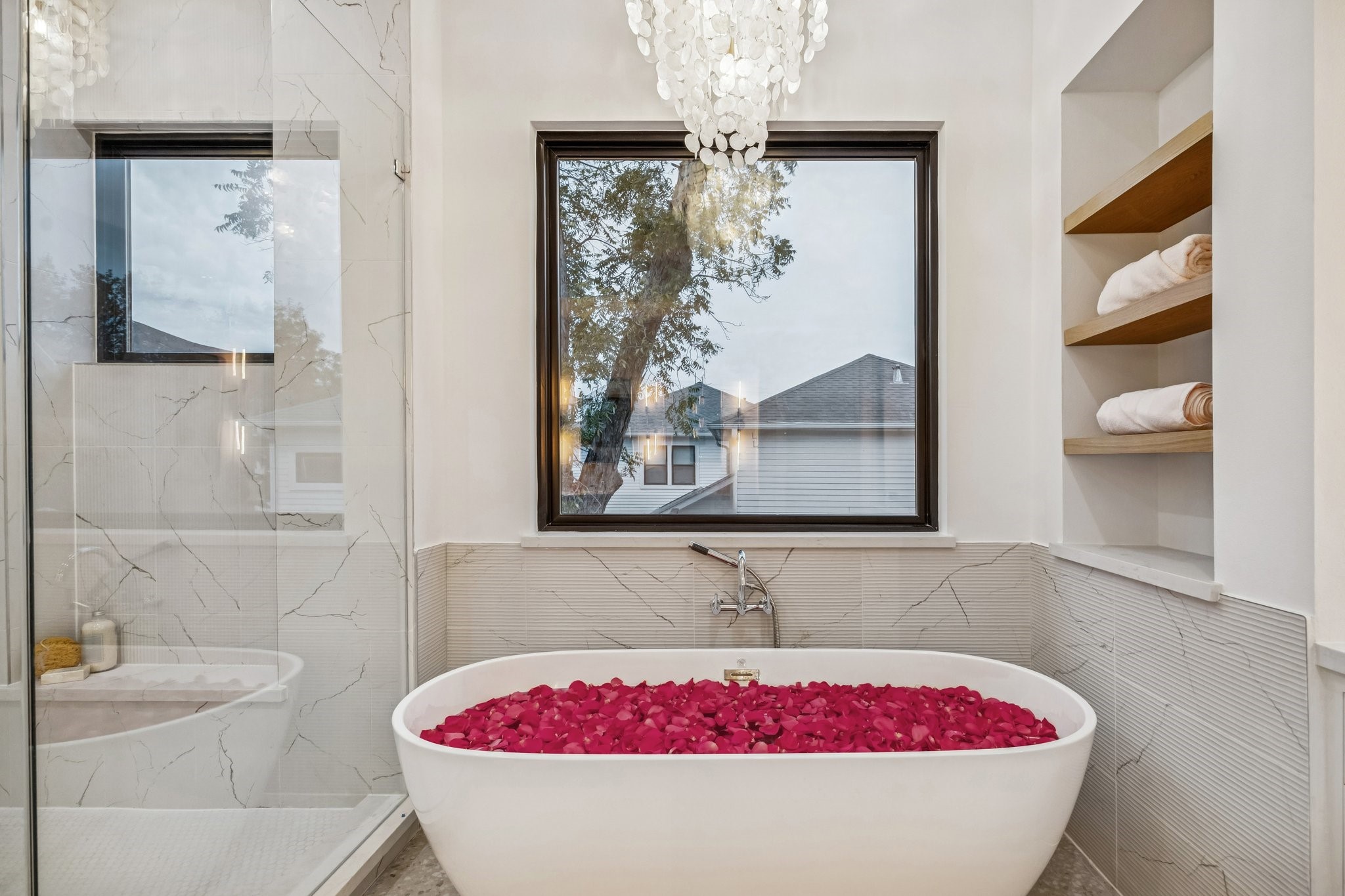 1204 West Drew Street Houston, TX 77006 - Photo 24 of 32 71 Inch Soaking Tub with a Wall Mounted Tub Filler, Ribbed Marble Tile Tub Surround, Glossy
Bronze Tiered Chandelier with Natural White Shell, White Oak Floating Shelves with a Natural Stain.