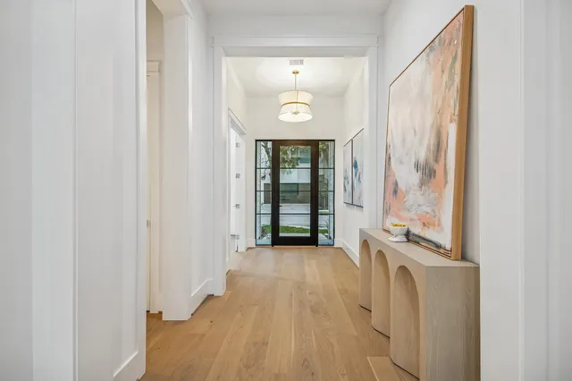 a view of a hallway with wooden floor and a large window