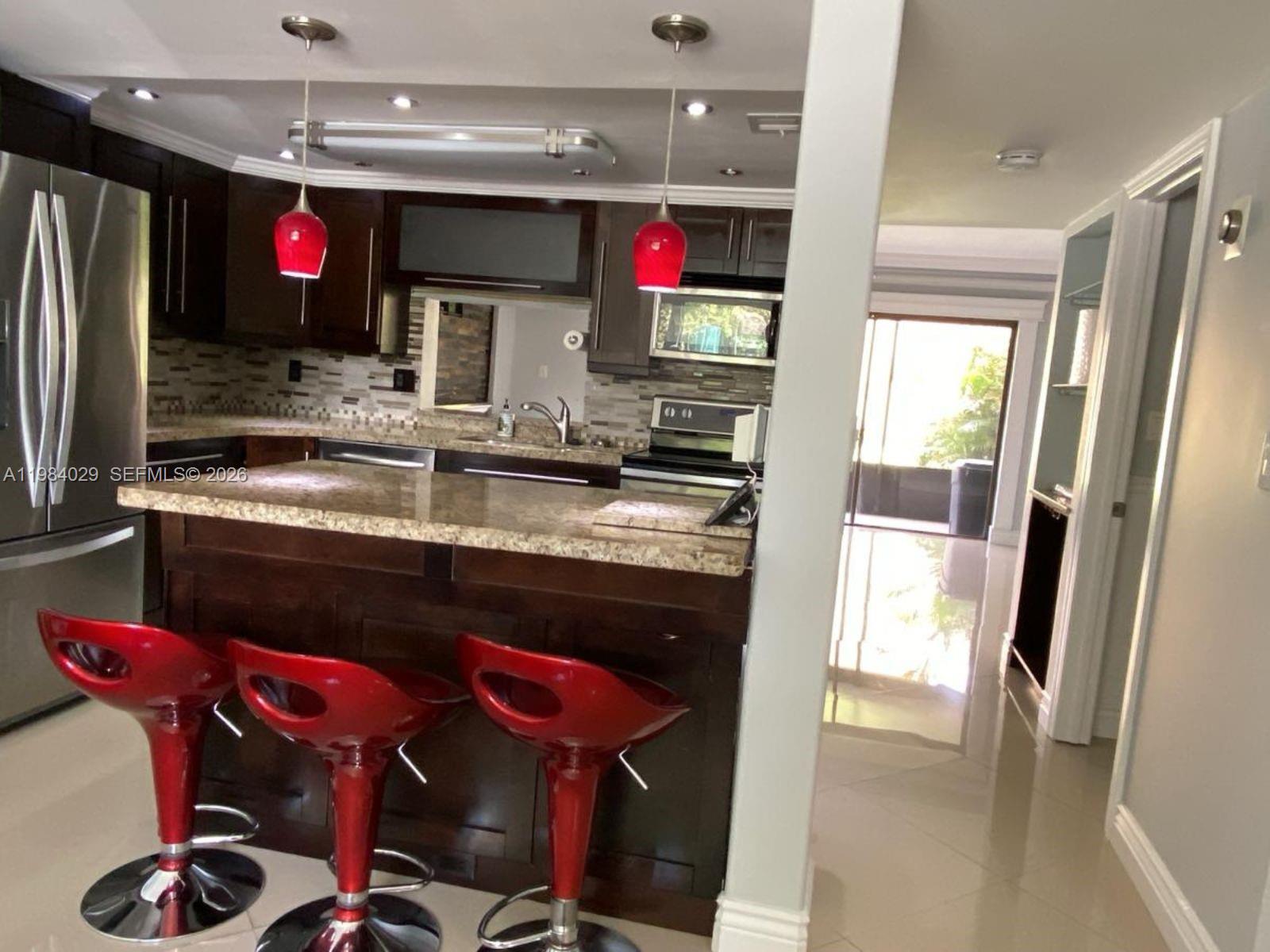 3282 North Pine Island Road, Unit 301 Sunrise, FL 33351 - Photo 4 of 22 a kitchen with stainless steel appliances granite countertop a refrigerator and a sink