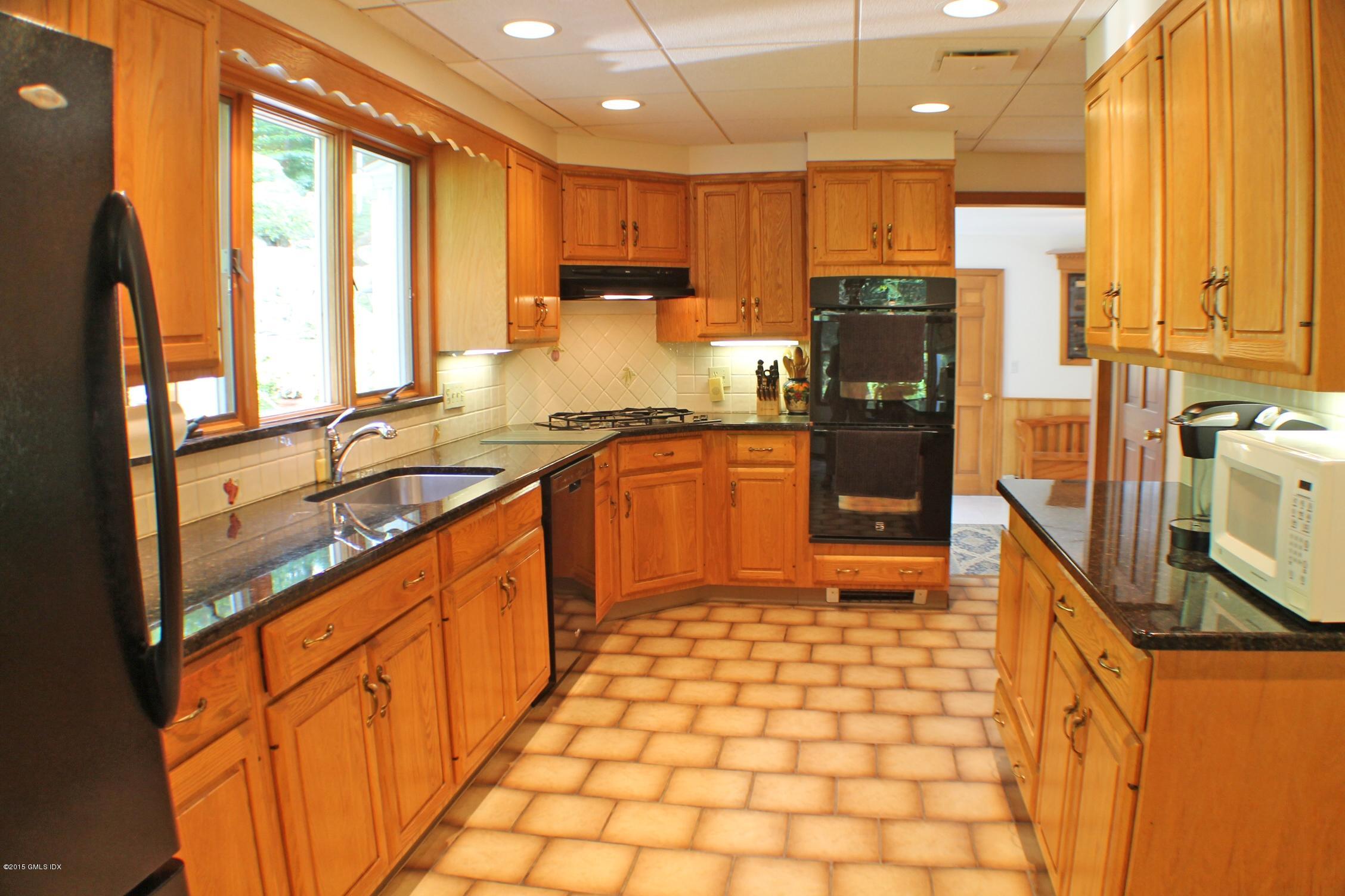 237 Chestnut Hill Road Stamford, CT 06903 - Photo 7 of 18 a open kitchen with stainless steel appliances granite countertop a refrigerator a sink dishwasher a stove with wooden cabinets and floor