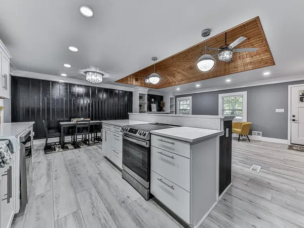 a kitchen with stove and wooden floor