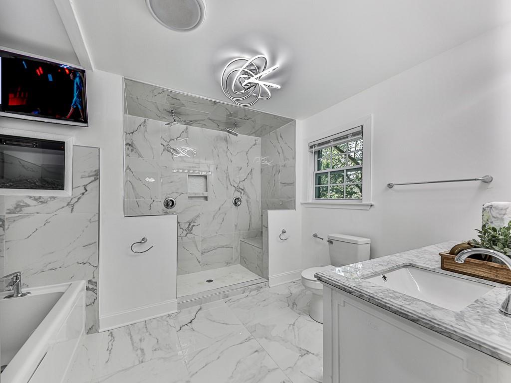 1564 Bubbling Creek Road Northeast Brookhaven, GA 30319 - Photo 21 of 34 a bathroom with a granite countertop sink a toilet and shower