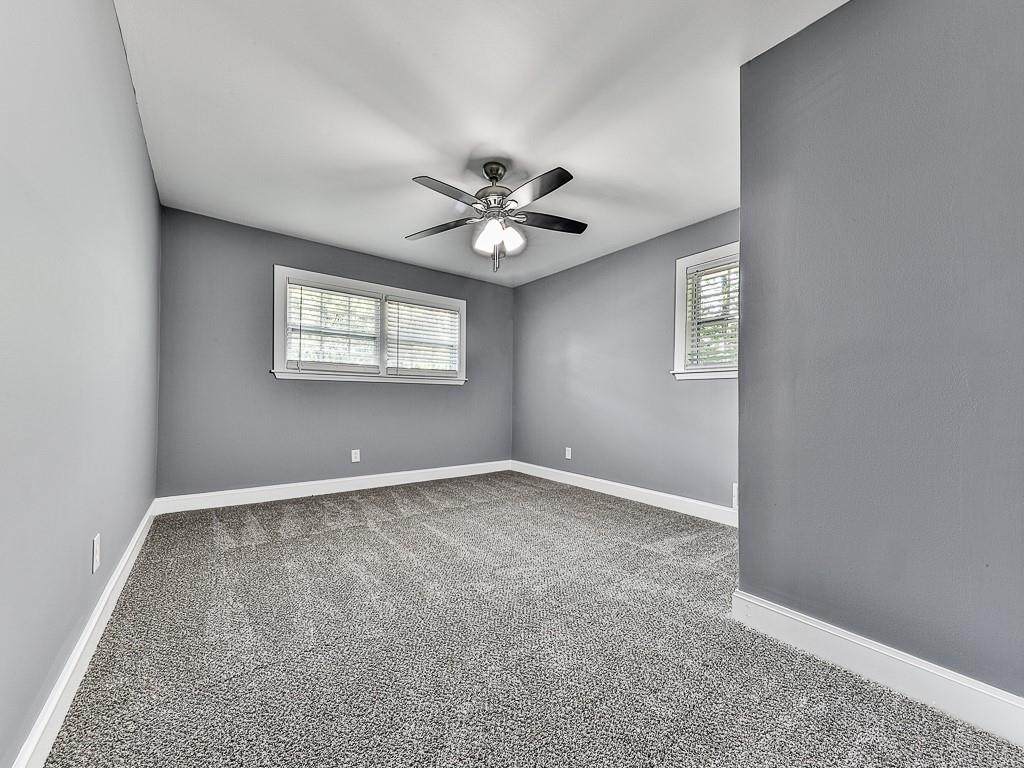 1564 Bubbling Creek Road Northeast Brookhaven, GA 30319 - Photo 23 of 34 an empty room with windows and chandelier fan