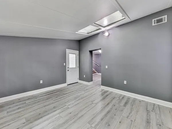 a view of a big room with wooden floor and windows