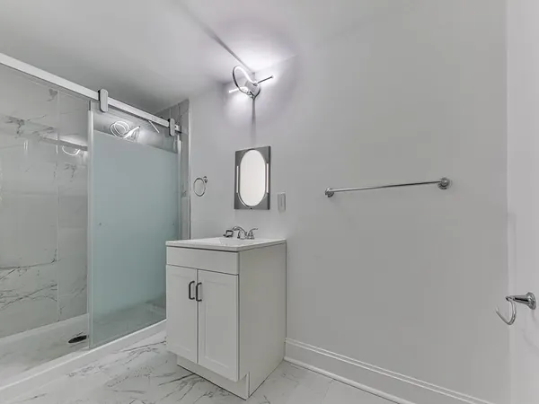 a bathroom with a granite countertop sink a shower and mirror