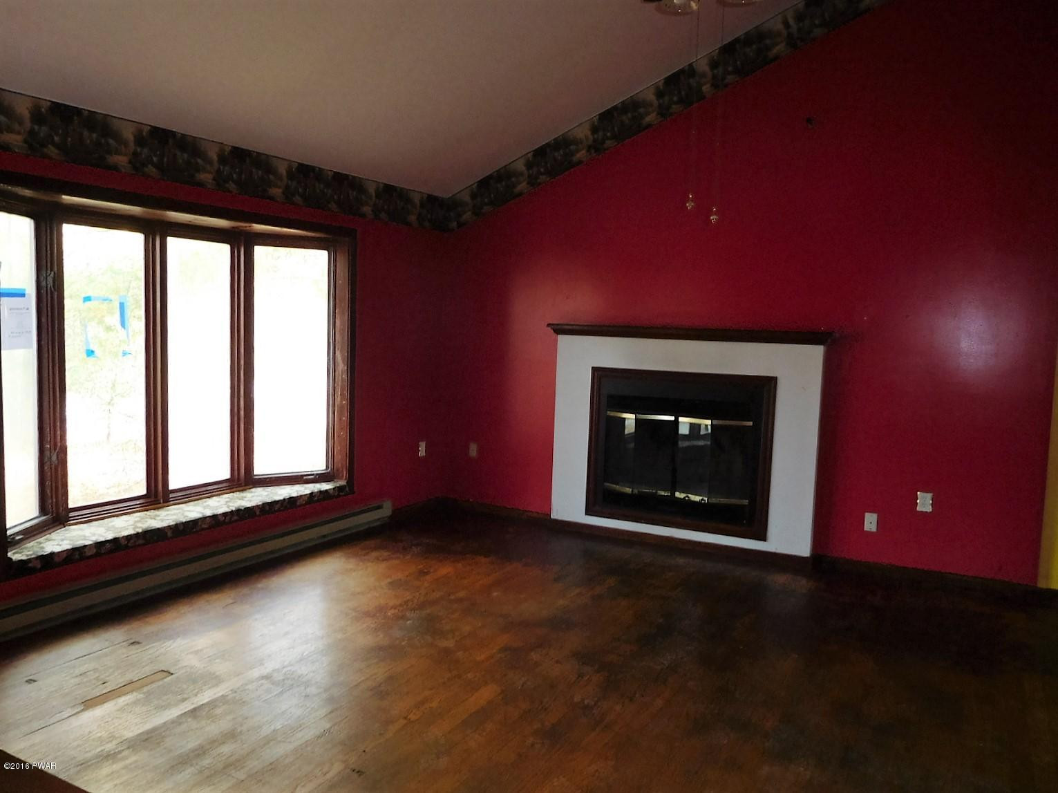 1021 Dancing Ridge Road East Stroudsburg, PA 18302 - Photo 7 of 28 a view of an empty room with a fireplace and a window