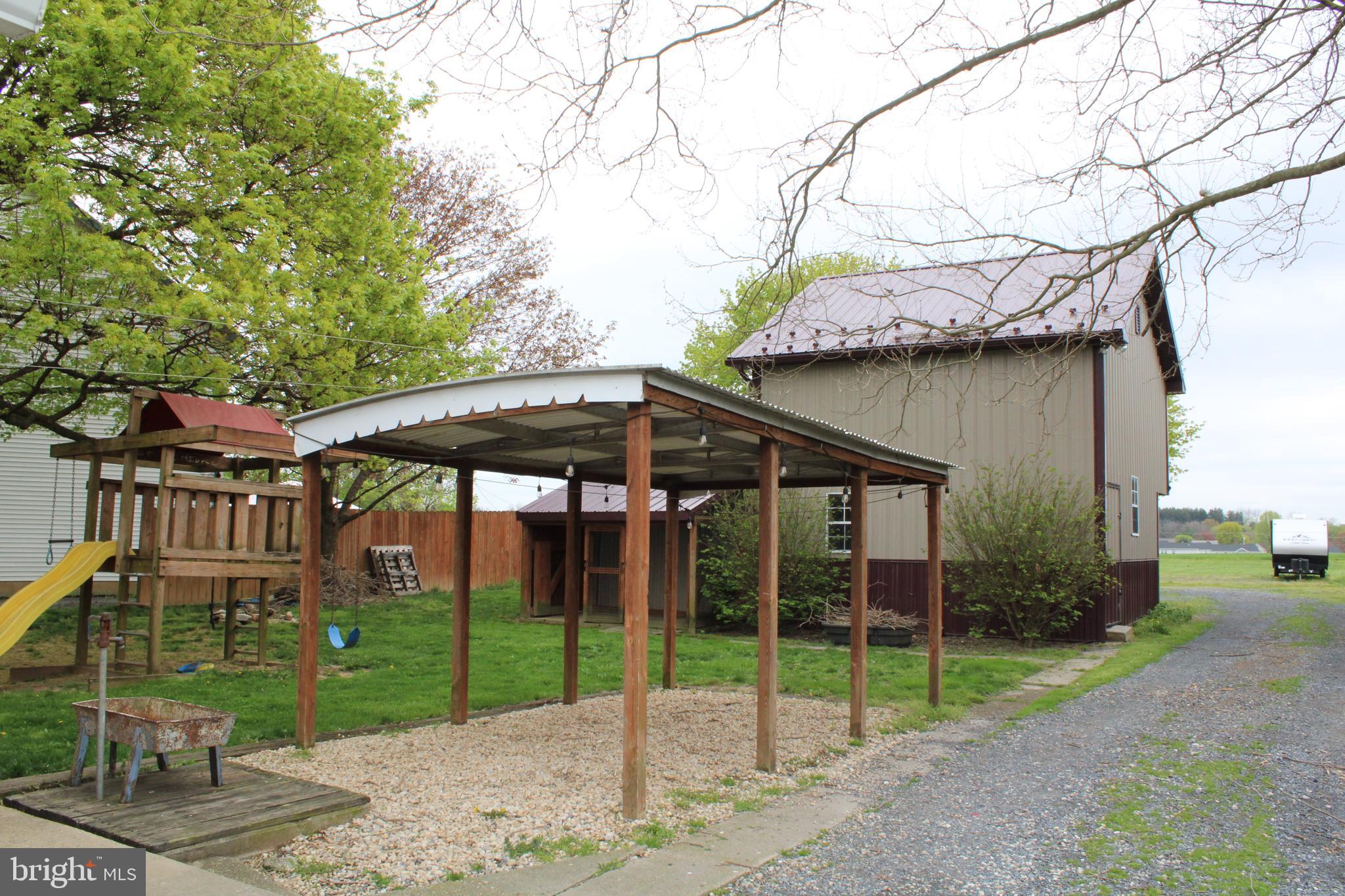 165 Short Road Stevens, PA 17578 - Photo 4 of 19 a view of a barn with a yard table and chairs under an umbrella