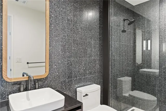 a bathroom with a toilet a sink a shower and mirror