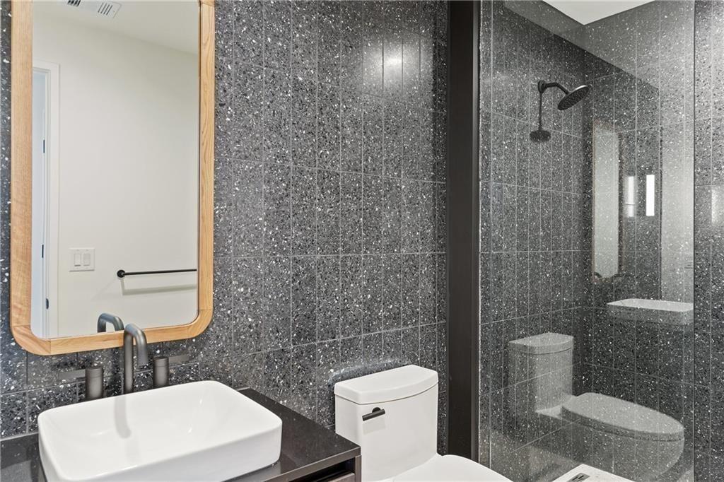 48 East Avenue, Unit 1503 Austin, TX 78701 - Photo 15 of 40 a bathroom with a toilet a sink a shower and mirror