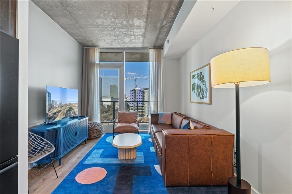 48 East Avenue, Unit 1503 Austin, TX 78701 - Photo 3 of 40 a living room with furniture and a wooden floor
