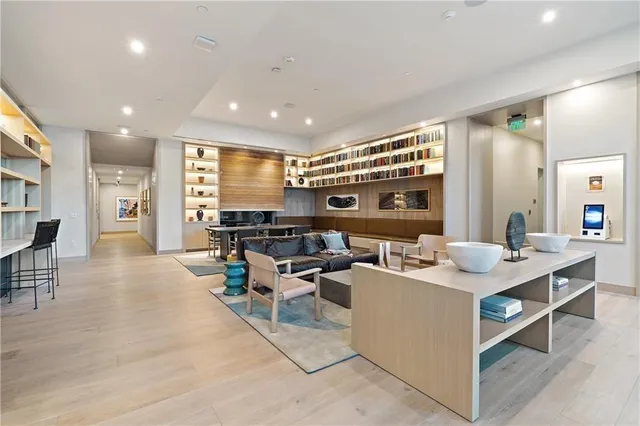 a living room with couches and kitchen view with wooden floor