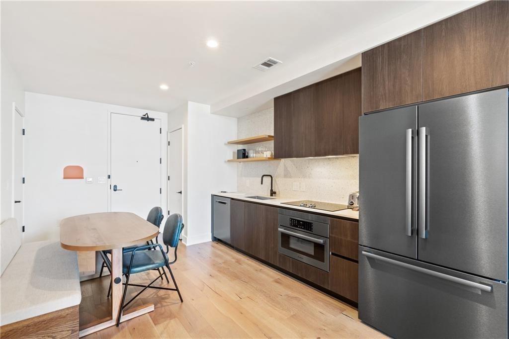 48 East Avenue, Unit 1503 Austin, TX 78701 - Photo 5 of 40 a kitchen with stainless steel appliances a refrigerator and a dining table