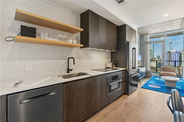 a kitchen with stainless steel appliances a sink stove and cabinets