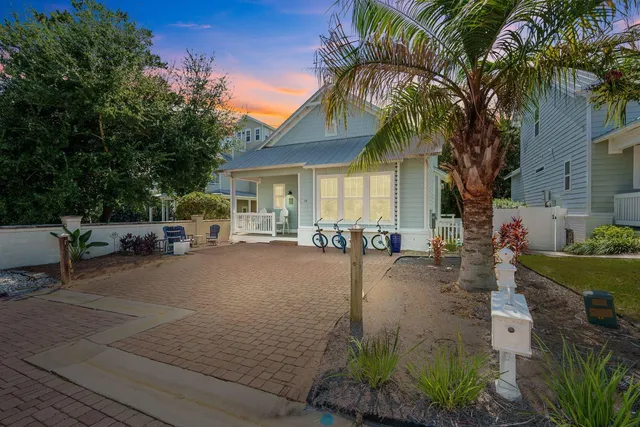 a view of a patio with table and chairs potted plants and a palm tree