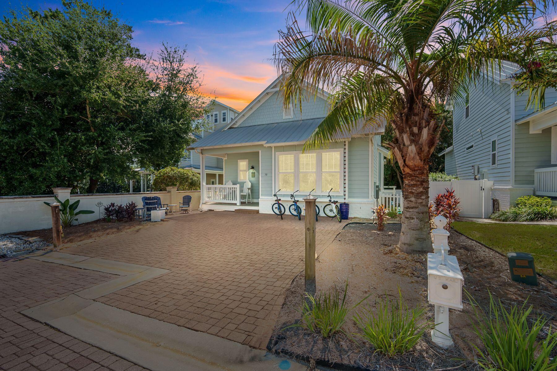 a view of a patio with table and chairs potted plants and a palm tree