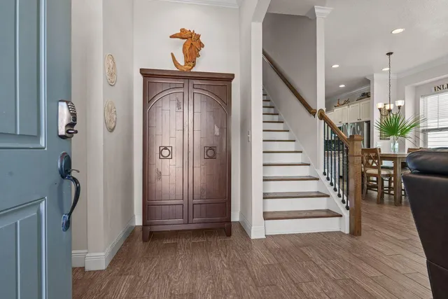 a view of a hallway with wooden floor and staircase