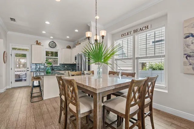 a dining room with furniture potted plants and wooden floor