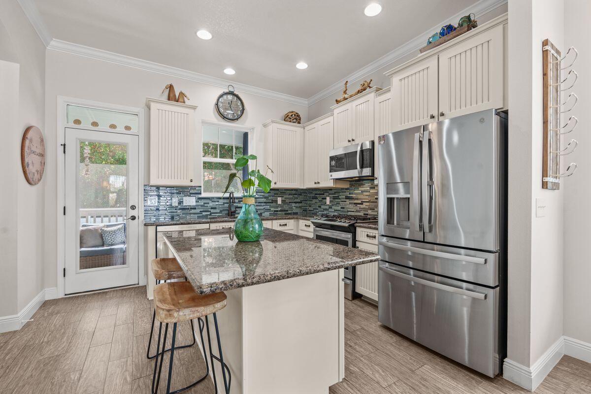 38 Inlet Cove Inlet Beach, FL 32461 - Photo 8 of 29 a kitchen with stainless steel appliances granite countertop a refrigerator a stove a sink and a dining table with wooden floor