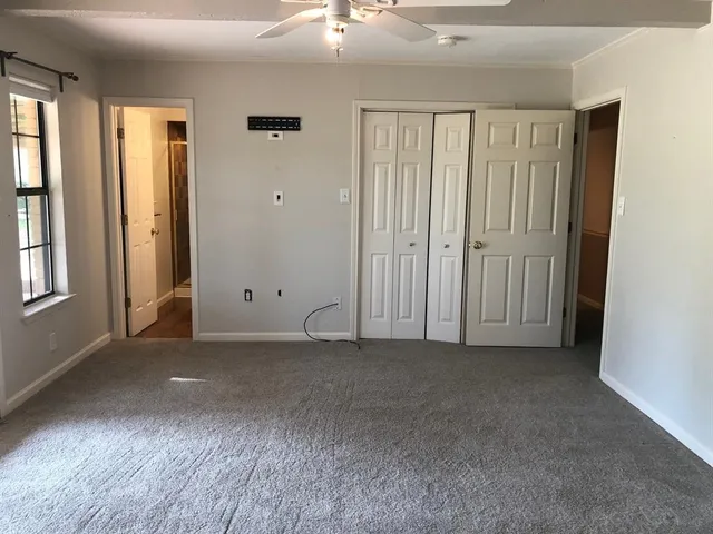 an empty room with windows and closet