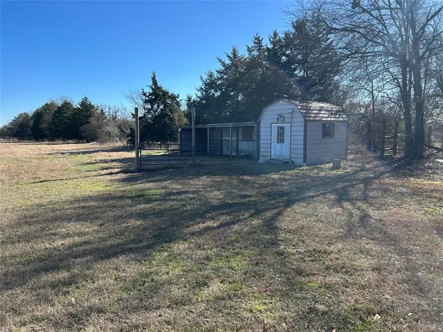 a view of a yard with wooden fence